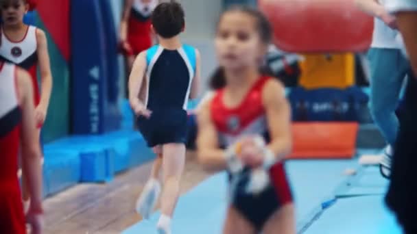 RUSIA, KAZAN 27-12-20: entrenamiento deportivo - niño de gimnasia saltando por encima de la barrera en la arena deportiva — Vídeo de stock