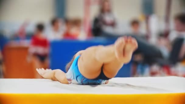 RUSIA, KAZAN 27-12-20: chica gimnasta saltando sobre la colchoneta y apoyándose en sus manos — Vídeo de stock