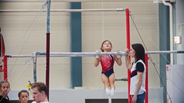 РОССИЯ, КАЗАН 27-12-20: гимнастическая девушка отдыхает на гимнастическом баре — стоковое видео