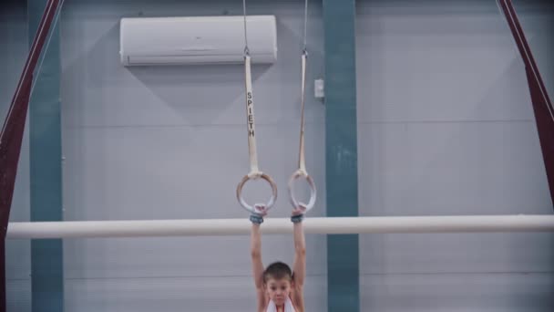 RÚSSIA, KAZAN 27-12-20: pequeno ginasta exercitando-se nos anéis esportivos — Vídeo de Stock