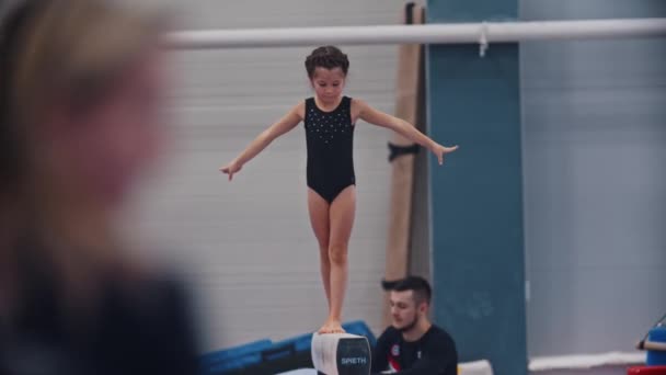 RUSIA, KAZAN 27-12-20: niña gimnástica balanceándose en la barra — Vídeo de stock