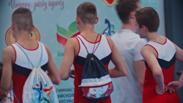 RUSSIA, KAZAN 27-12-20: een groep gymnastieke tienerjongens met rugzakken loopt weg van het sportveld — Stockvideo