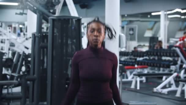 Een zwarte vrouw springt in de sportschool — Stockvideo