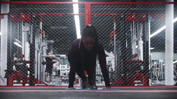 Een Afrikaans-Amerikaanse vrouw doet push-ups op de yoga mat — Stockvideo