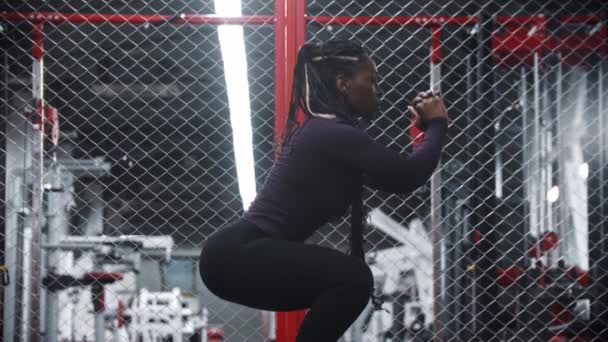 An african-american with pumped butt sportive woman squatting in a gym — Stok video