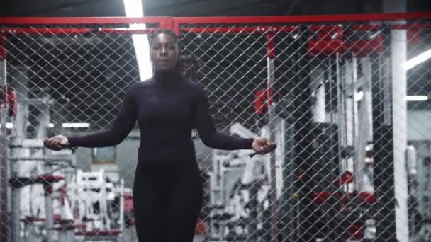 Una mujer afroamericana saltando sobre la cuerda en el gimnasio - ejercicios de resistencia — Vídeos de Stock