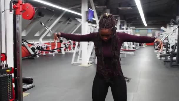 스포츠 훈련 - 아프리카계 미국인 여자가 무게에 부착 된 보유자를 끌어당겨 손을 훈련시키는 모습. — 비디오