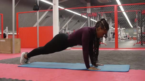 Entrenamiento deportivo - mujer afroamericana haciendo flexiones en el gimnasio — Vídeos de Stock