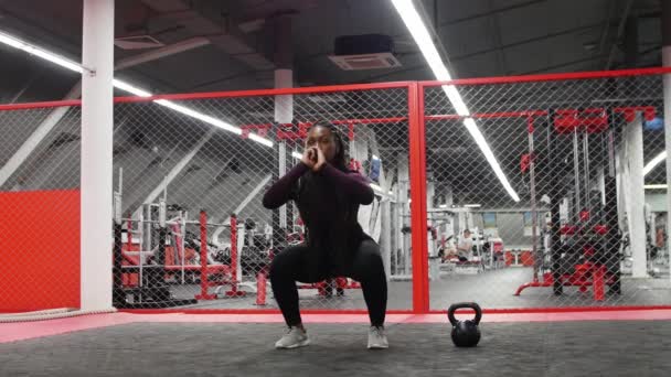 Deportes en el gimnasio - mujer afroamericana en cuclillas — Vídeos de Stock