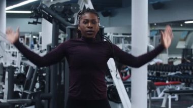 Spor salonunda spor. Uzun örgüleri olan Afro-Amerikan bir kadın tek bir noktada zıplıyor.