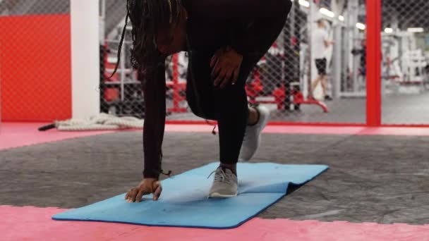 Deportes en el gimnasio - mujer afroamericana calentándose en la esterilla de yoga — Vídeos de Stock