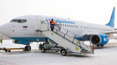 10-02-2021 KAZAN, RUSSIA, Kazan Uluslararası Havaalanı: POBEDA kampanyasından beyaz bir uçak - bir havaalanı merdiveni