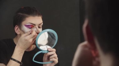 Sürükleme sanatçısı - genç adam iç köşeye kırmızı göz farı sürüyor