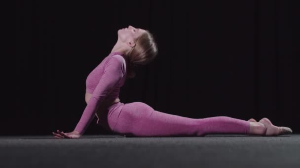 Joven gimnasta femenina calentándose antes del entrenamiento - calentando su espalda — Vídeo de stock