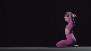 Genç bayan jimnastikçi saçını topuz yapıyor.