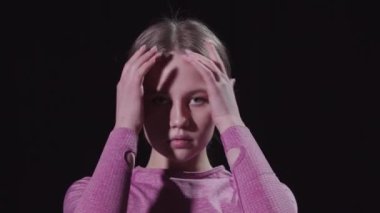 Genç ve güzel bir jimnastikçi saçını topuz yapıp kameraya bakıyordu.