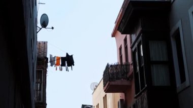 Giysiler binanın dışındaki ipte asılı.