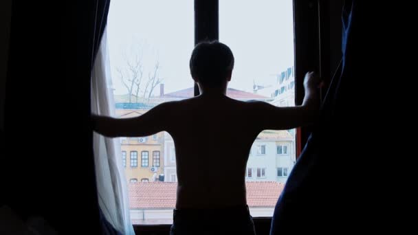 Νεαρός γυμνός άντρας ανοίγει κουρτίνες το πρωί — Αρχείο Βίντεο