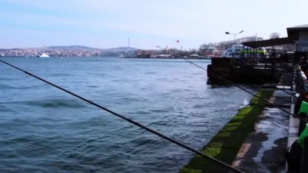 Hav bort från staden och fiskespön står på kanten av plattformen i hamnen — Stockvideo