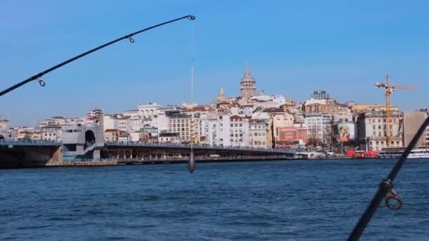 Meer in der Nähe der Stadt und Angelruten, die am Rand der Plattform stehen — Stockvideo