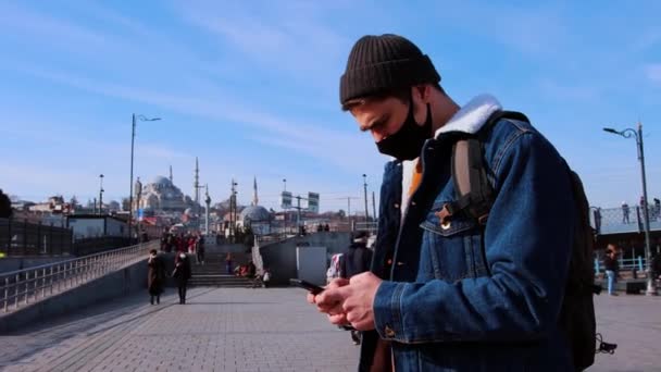 Un joven viajero en Turquía - usando su teléfono para navegar en una calle concurrida — Vídeo de stock