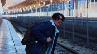 Genç gezgin tren yolu için koşuyor.