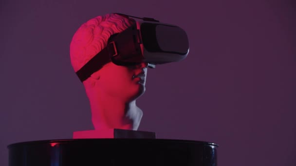 Uma escultura de cabeça grega em óculos VR no suporte iluminação vermelha de diferentes ângulos — Vídeo de Stock