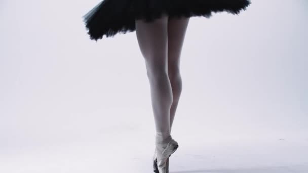 Молодая балерина в черном платье ходит на пуантах — стоковое видео