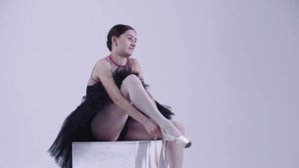 Młoda kobieta balerina w czarnej sukience zakładanie szpiczastych butów — Wideo stockowe