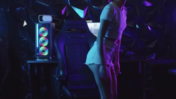 Dívka hráč sedí na židli v herním klubu a zavazuje si boty — Stock video