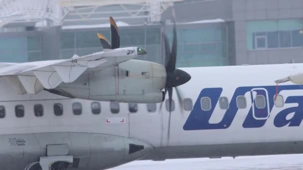 10-02-2021 KAZAN, RUSIA, Aeropuerto Internacional de Kazán: un avión blanco con grandes válvulas de la campaña UTAIR que se mueve en una pista nevada — Vídeo de stock