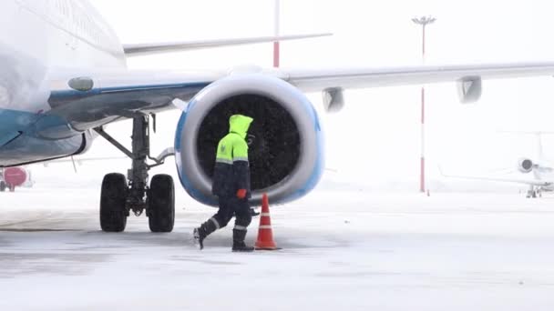 10-02-2021 KAZAN, RUSSIA, Міжнародний аеропорт Казані: турбіна літака на аеродромі і робочі люди йдуть пішки - зимовий час — стокове відео