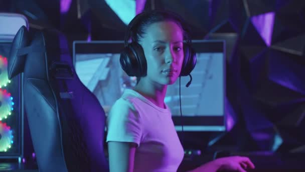 Meisje gamer draait weg van de PC en kijken in de camera - zuigen lolly — Stockvideo