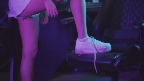 Eine Frau legt ihr Bein auf den Stuhl im Spielclub und schnürt ihren Schuh — Stockvideo
