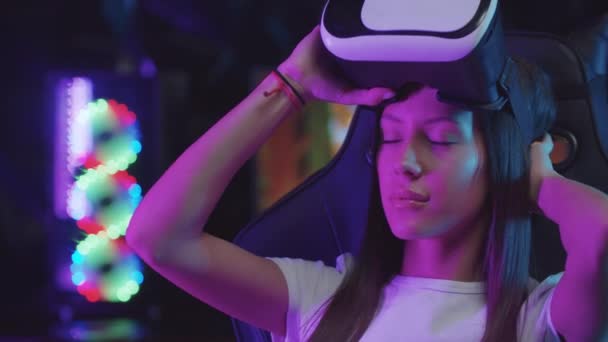 Meisje gamer zetten op een VR bril in neon verlichting — Stockvideo