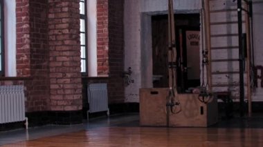 İki sıska kadın spor salonuna giriyor ve biri saçını at kuyruğu yapıyor.