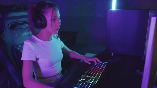 Jeune femme joueuse concentrée jouant en utilisant PC dans le club de jeu — Video