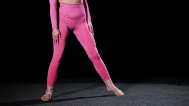 Gymnastics - young woman in pink costume sits down in splits and bending to the sides — Stock Video