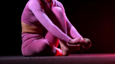 Jimnastik - Pembe kostümlü genç bir kadın antrenman için özel çoraplar giyiyor