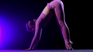 Jimnastik - genç plastik kadın egzersiz yapıyor - mavi neon ışıklı