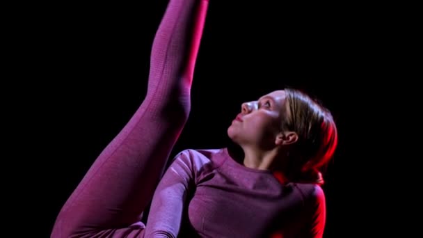 Gimnasia - joven mujer de plástico levantando su pierna mostrando su estiramiento - iluminación de neón rojo — Vídeos de Stock