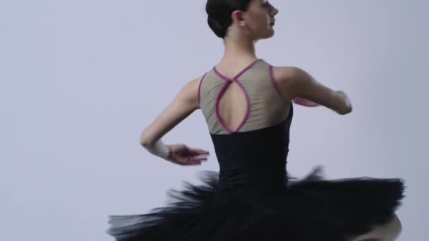 Junge Ballerina im schwarzen Kleid dreht Pirouette — Stockvideo