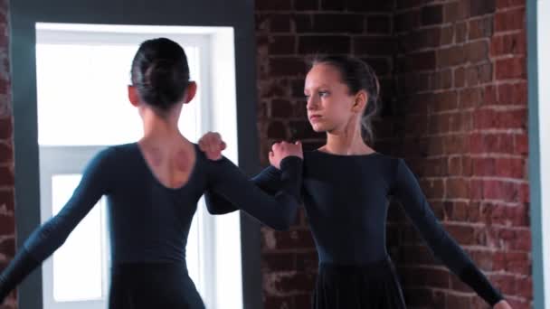 Duas meninas bailarinas dançando em vestidos escuros no treinamento no estúdio — Vídeo de Stock