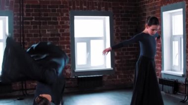 Stüdyoda uzun siyah elbiseler içinde dans eden iki balerin kız.