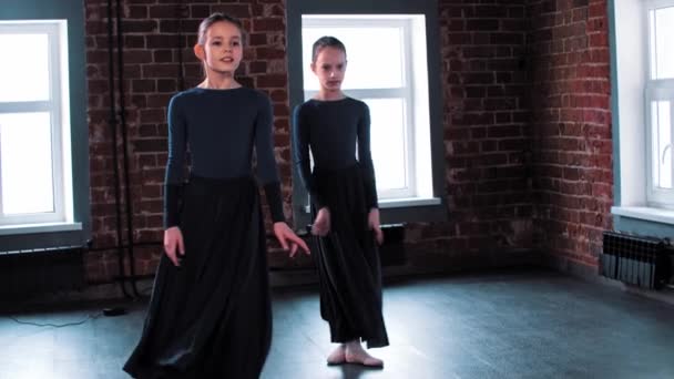 Duas bailarinas dançando em longos vestidos escuros no estúdio — Vídeo de Stock