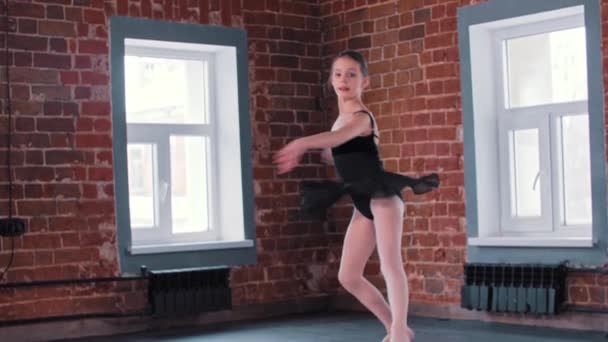 Taniec baletowy - mała gimnastyczka tańcząca w czarnym garniturze na treningu — Wideo stockowe
