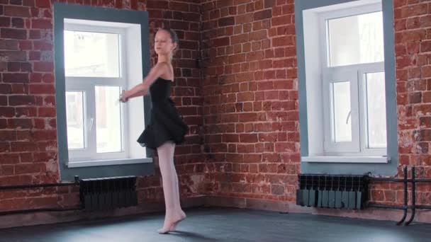 Danse de ballet - une petite fille de gymnastique dansant en costume noir pendant l'entraînement et jouant des pirouettes — Video