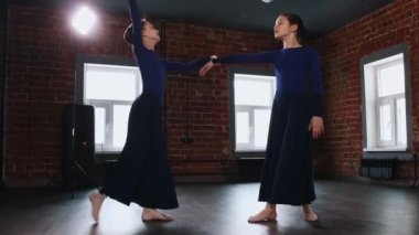 Bale dansı - uzun elbiseli iki balerin kız bir dans stüdyosunda