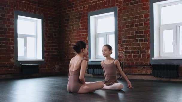 Ballet dancing - two ballerina girls sitting in a dance studio and talking — Stock Video