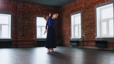 Bale dansı - iki küçük kız uzun mavi elbiseler içinde zarif bir şekilde dans ediyorlar.